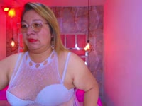 Mit ihren üppigen Kurven und einem Körper, der vor Lust nur so strotzt, weiß sie genau, wie sie dich erregen kann. Ihr blondes Haar unterstreicht ihren verschmitzten Blick, und ihre Erfahrung macht jedes Treffen zu einer unwiderstehlichen Reise voller Lust und Versuchung. Sie wird dich mit ihrer reifen Sinnlichkeit, ihren üppigen Attributen und ihrer unverschämt provokanten Art, mit deinen Wünschen zu spielen, in ihren Bann ziehen.